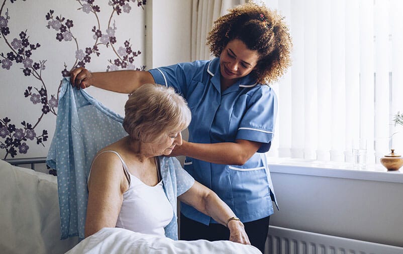 caregiver helping senior get dressed