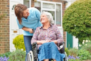 Carer With Senior Woman In Wheelchair