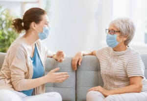 masked-caregiver-and-senior-talking
