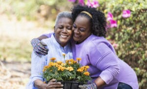 Senior lady, daughter gardening, hug