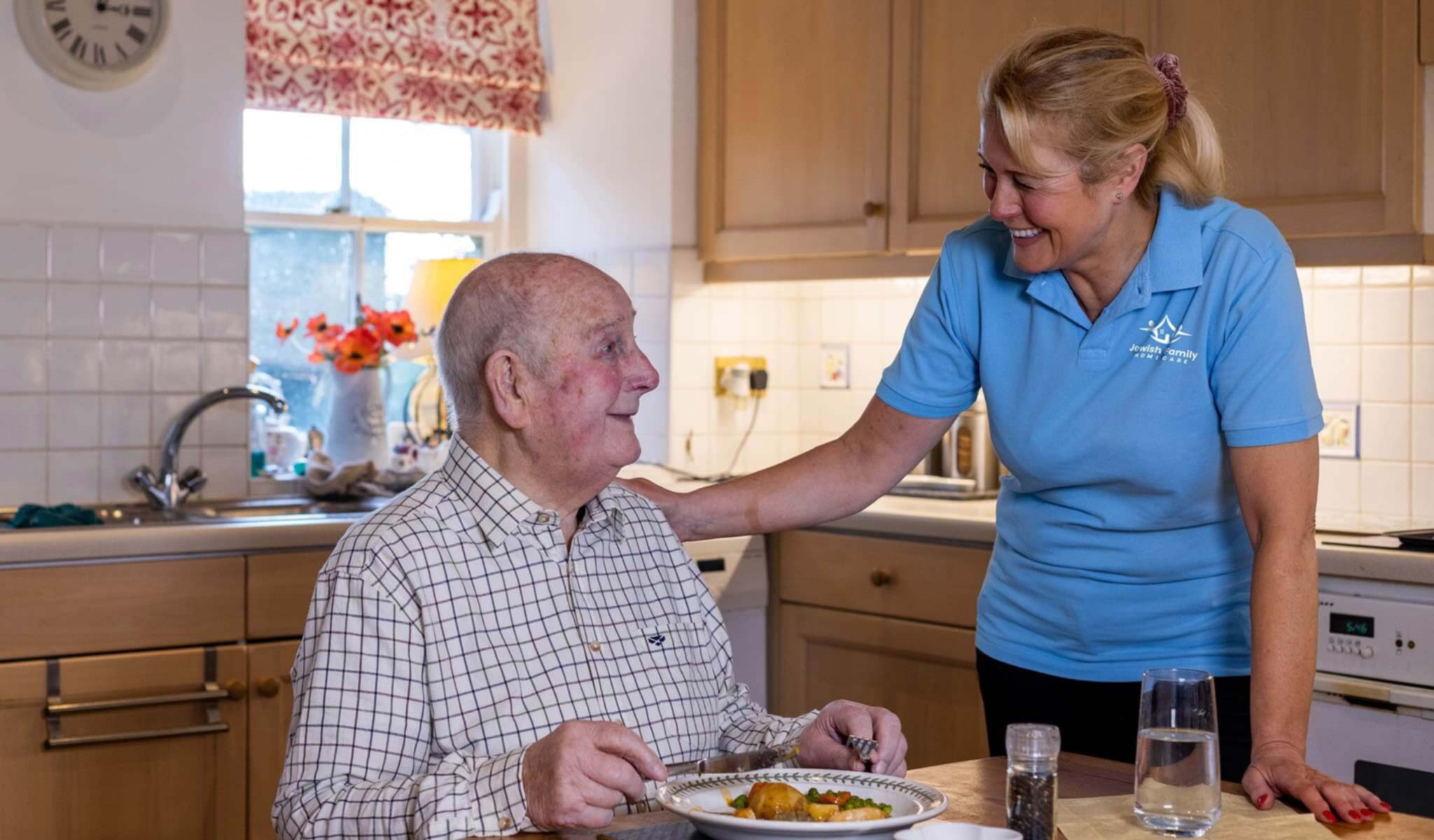 Caregiver serving senior client his meal