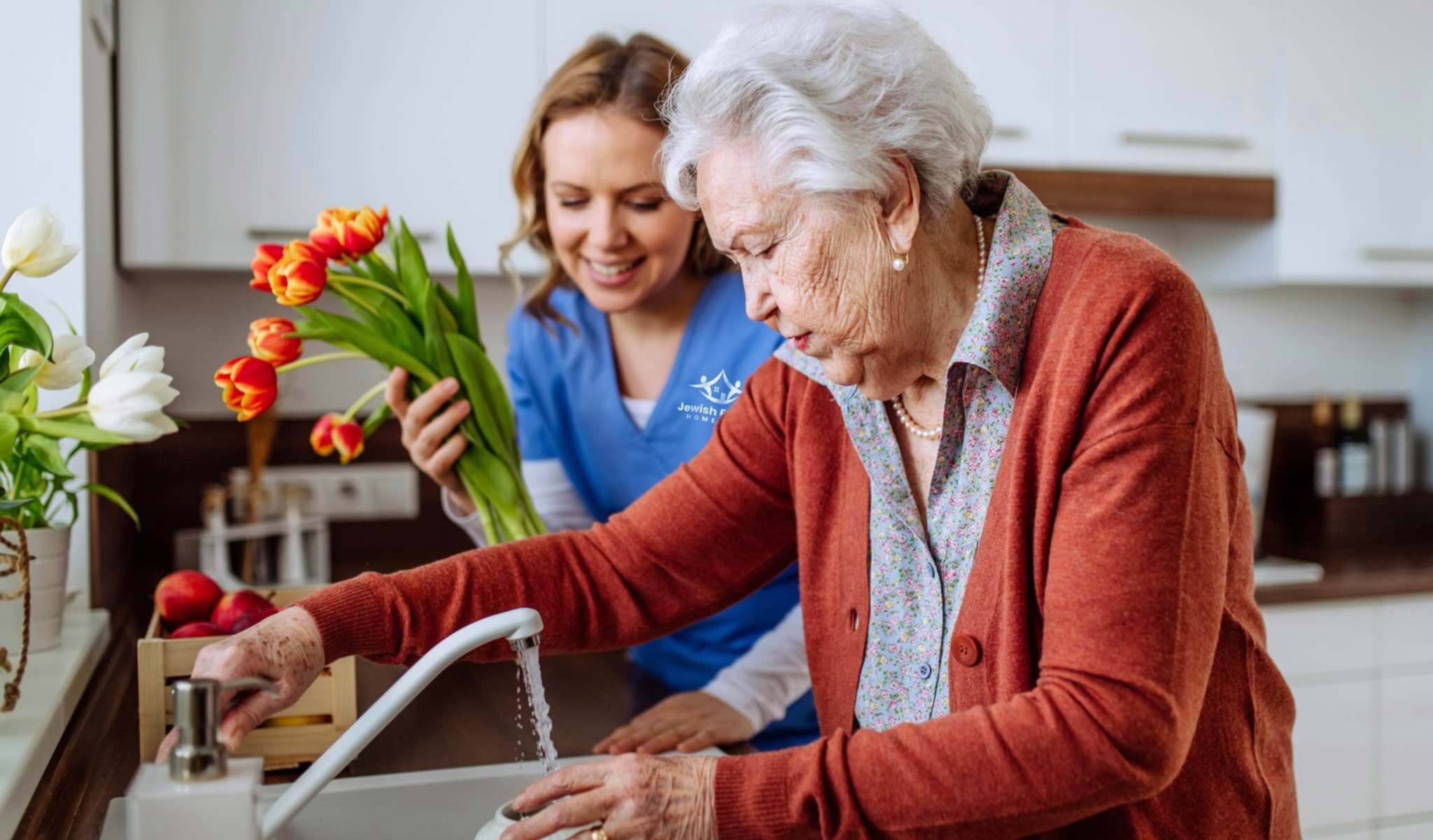 Senior client and caregiver putting flowers in a vase