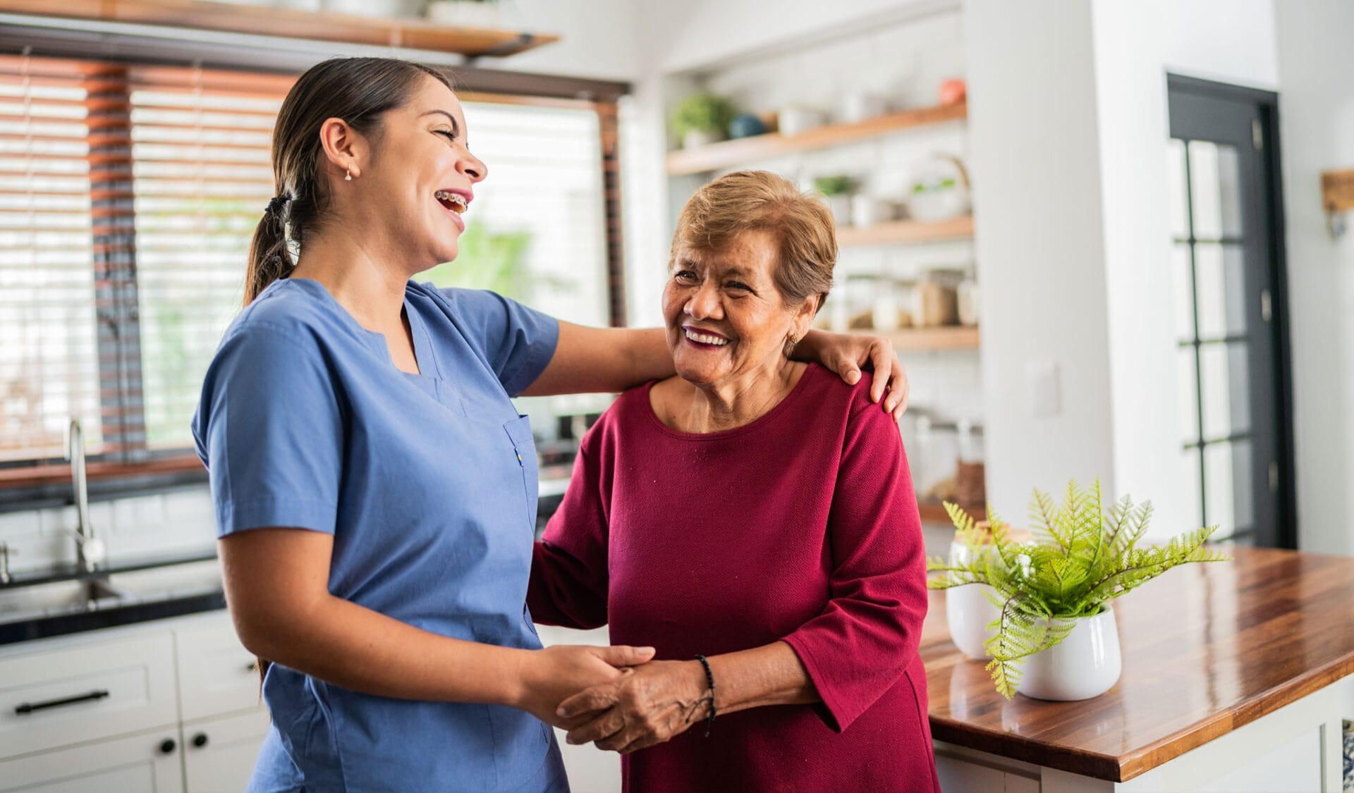 happy caregiver with senior lady laughing